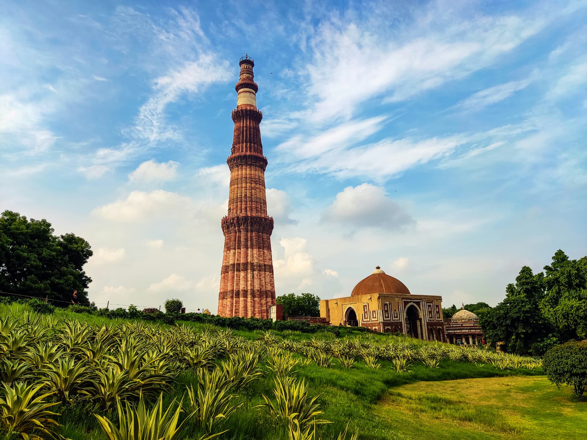 Qutub Minar de Delhi rodeado de jardines